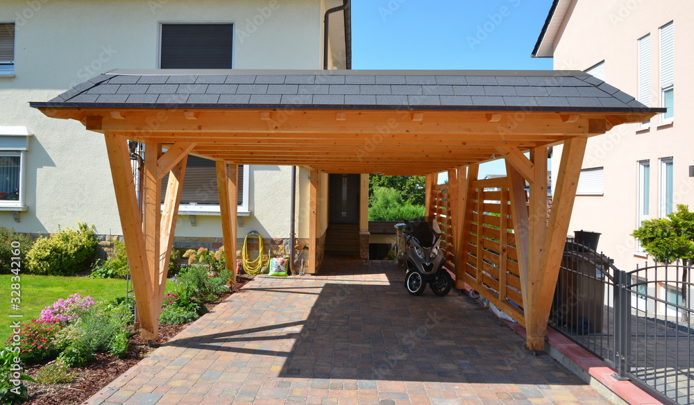 Neuer Carport aus lasiertem Holz mit beschichteten Metall-Schindeln und Dachrinne