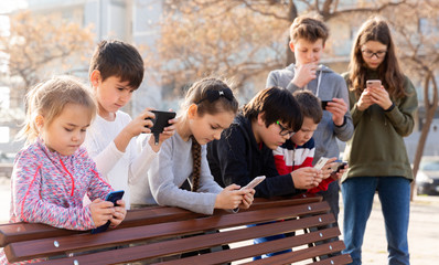 Children addicted in their phones outdoors