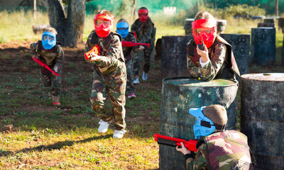 Wall Mural - Group of ordinary kids playing paintball