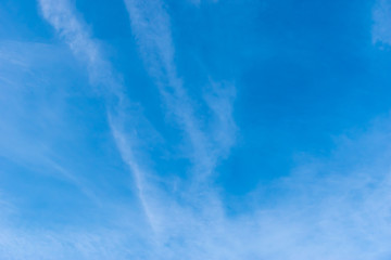 The wide angle shot of the bright blue sky with feather clouds
