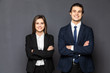 © F8  \ Suport Ukraine - Concept of partnership in business. Young man and woman standing back-to-back with crossed hands against gray background