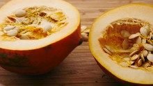 Splitting An Acorn Squash In Half. The Raw Halves Of The Hearty Autumn Gourd Are Split Into Two Ready To Be Roasted And Eaten. 