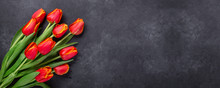 Greeting Card For Mother's Or Women's Day. Bouquet Of Red Tulips On A Dark Stone Table. Spring Background. Top View. Copy Space