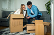© Novak - Couple relocating to new apartment and unpacking boxes