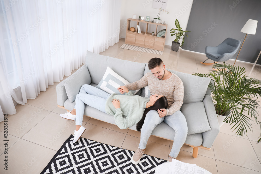 Young couple resting on sofa at home