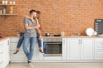 Poster - Happy young couple in kitchen