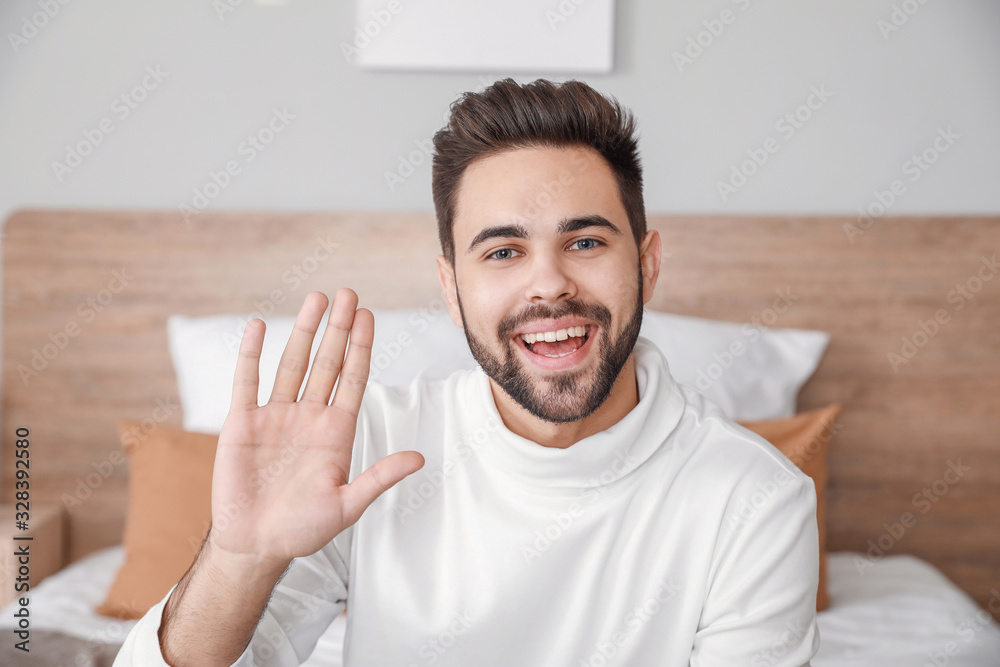 Young man video chatting at home