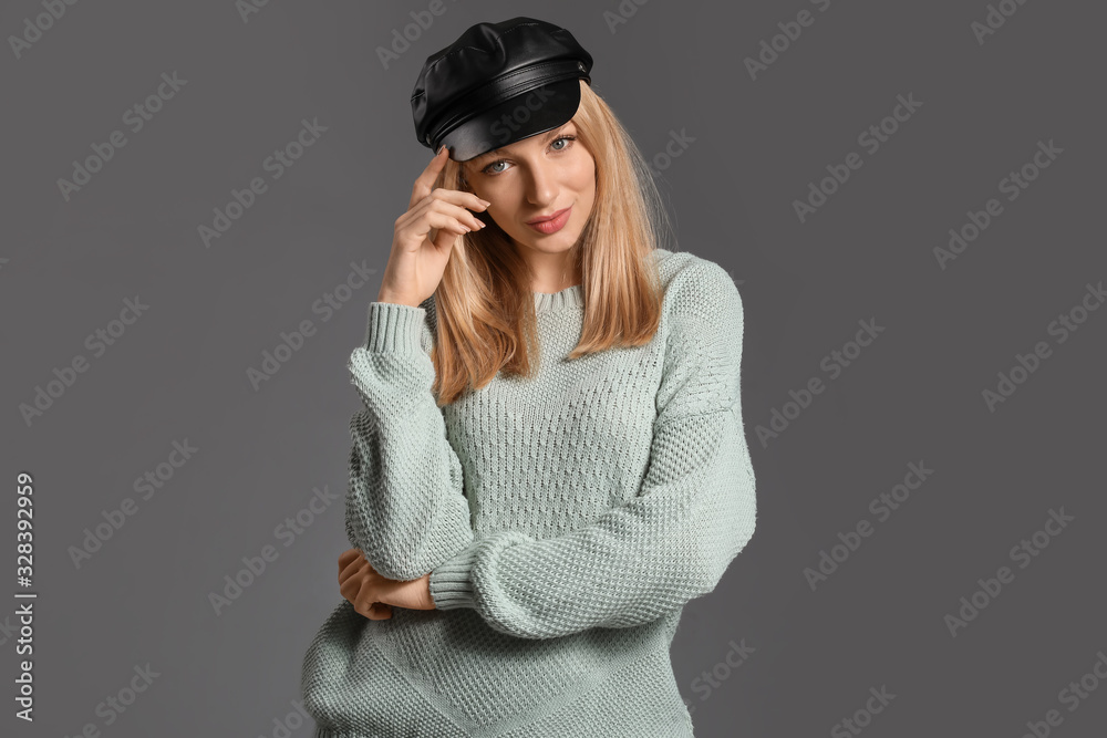 Young woman in warm sweater on grey background