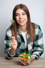 Girl eats vegetable salad with lots of vitamins