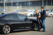 © Maksymiv Iurii - Happy young couple chooses and buying a new car for the family.