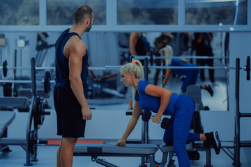 Fitness instructor with girl on training in fitness center