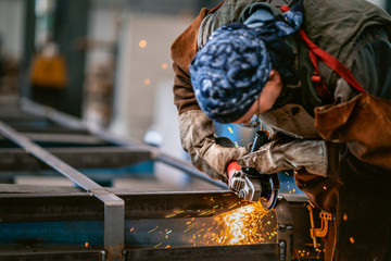 Factory worker grinding a metal,close up