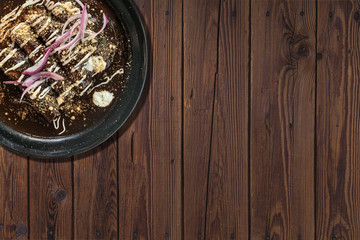 Enchiladas de mole with chicken, on wooden table.