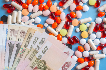 Pharmacy background. Business finance. Russian money and pills on blue backgrouind. Illness, disease, symptom.