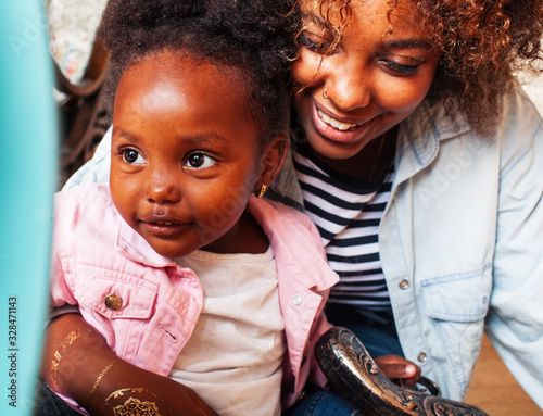 Fotomural adorable sweet young afro-american mother with cute little daughter, hanging at