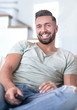 © ASDF - close up. young man sitting on sofa.