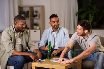 Sticker - leisure games, friendship and gambling concept - happy male friends playing cards and drinking beer at home at night