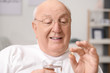 © Pixel-Shot - Portrait of elderly man taking medicine at home