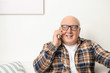 © Pixel-Shot - Portrait of elderly man talking by phone at home