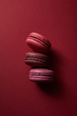 top view of delicious colorful french macaroons on red background