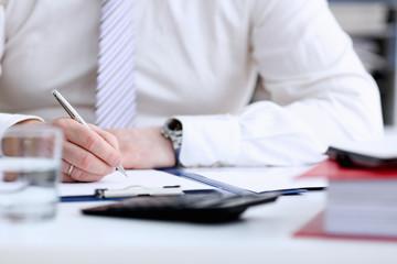  Male arm in suit and tie hold silver pen filling schedule in notepad at office workplace closeup. Legal law consult assistance gesture or finance investment advisor clerk job information gesture