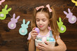 © producer - happy little child girl holding basket with painted Easter eggs. Easter day