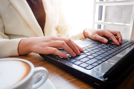 Cropped shot view of business woman’s hands typing the labtop with blank copy space screen for your information content or text message.