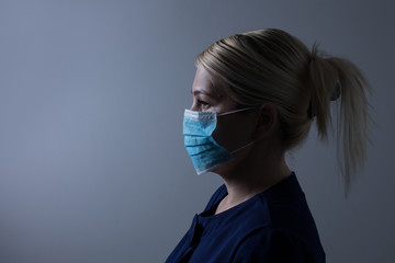 an attractive young woman wears a paper face mask to protect herself from the H1N1 Virus, isolated on white, with room for your text