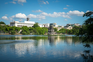 Wall Mural - Hoan Kiem lake or Sword lake, Ho Guom in Hanoi, Vietnam with Turtle Tower, on clear day with blue sky and white clouds