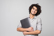 Handsome young curly haired man working on laptop computer standing of isolated on white background,