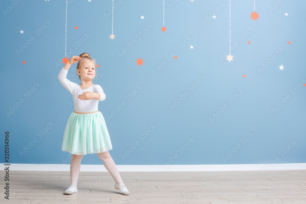 Cute little ballerina near color wall