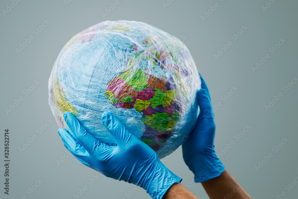 doctor with a world globe wrapped in plastic. - obrazy, fototapety, plakaty 