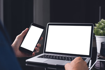 Canvas Print - Mockup of man using mobile smart phone and laptop computer