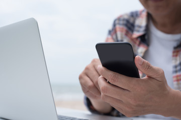 Canvas Print - Man using smartphone and working on laptop computer