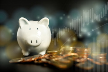 Piggy bank around with pile of coins with yellow-blue bokeh and financial graph, double exposure,  saving money concept