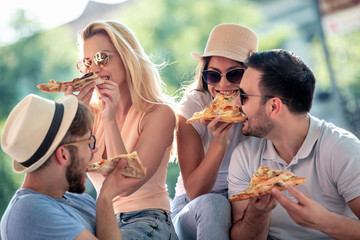 Wall Mural - Group of young people eating pizza