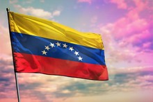 Fluttering Venezuela Flag On Colorful Cloudy Sky Background. Prosperity Concept.