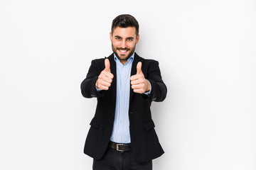 Young caucasian business man against a white background isolated with thumbs ups, cheers about something, support and respect concept.