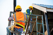 © visoot - Construction worker wearing safety harness and safety line working at high place.