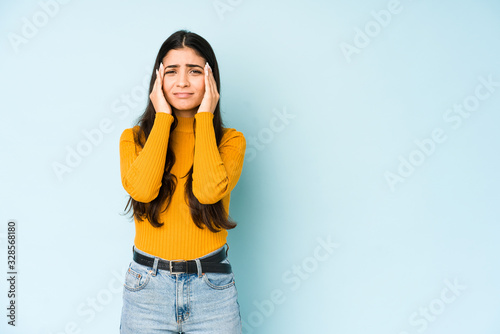 Fotografía Young indian woman isolated on blue background crying, unhappy with something, agony and confusion concept