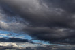 Dramatic storm dark grey cumulus clouds against blue sky background texture