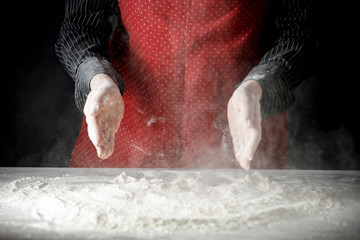 Wall Mural - Flour on a kitchen table on a black moody background in the morning light