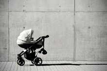 Baby Carriage In Front Of Concrete Wall