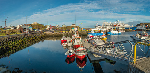 Panoramic view over sunset at Stykkisholmur (Stykkish) downtown and harbor with many fish restaurants, yachts, boats and a ferryboat towards Western Fjords, Iceland, summer