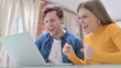 © stockbakers - Young Couple Celebrating Success on Laptop