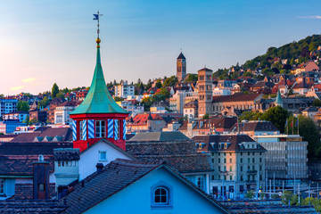 Fototapete - Aerial view over roofs and towers of Old Town of Zurich, the largest city in Switzerland at sunset.