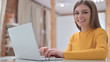 © stockbakers - Creative Young Woman Working on Laptop and Smiling at the Camera