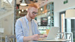 © stockbakers - Online Shopping by Redhead Man in Cafe