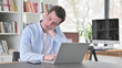 © stockbakers - Young Man with Neck Pain Working on Laptop