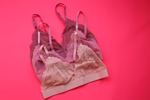 Bra Set On A Bright Pink  Background. Women's Underwear.Fashion Trendy Lace Lingerie.  Pink, Beige And Lilac Bra On A Pink Background.